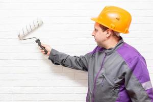 worker paints the white wall white cushion photo