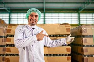 worker presenting products on the production line in the beverage factory. Manufacturer checks quality of food industry. photo