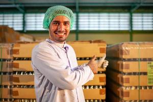 worker presenting products on the production line in the beverage factory. Manufacturer checks quality of food industry. photo