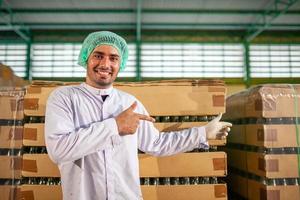 worker presenting products on the production line in the beverage factory. Manufacturer checks quality of food industry. photo