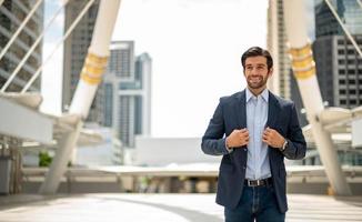 el retrato de un joven y apuesto hombre de negocios caucásico feliz con anteojos y vistiendo trajes azules profundos para un aspecto profesional. foto