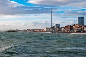 gente caminando por el paseo marítimo cerca de la playa en brighton. foto