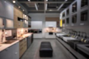 Scenic of modern kitchen abstract defocused blurred background furnished with stove, counter, compartment and kitchenware. Copy space for advertisement wording, website background. photo