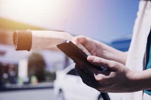 enchufar a mano un cargador en un enchufe de coche eléctrico.coche eléctrico o ev se está cargando en la estación foto