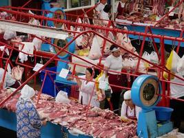 Almaty, Kazakhstan, 2019 - People in the meat section of the famous Green Bazaar of Almaty, Kazakhstan, with goods on display. photo