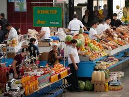 Almaty, Kazakhstan, 2019 - People in the meat section of the famous Green Bazaar of Almaty, Kazakhstan, with goods on display. photo