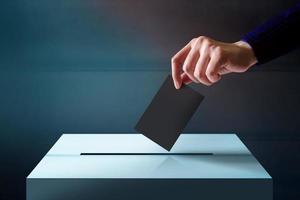 Hand Dropping a Ballot Card into the Vote Box, Polish and Dark Tone photo