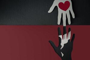 Donation Concept. Help, Care, Love, Support or Partnership. Paper Cut as Hands Shape hanging on the wall. look like the top one with a Red Heart trying to help the one below photo