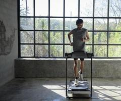 A man walking and exercising on a treadmill. photo