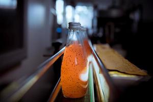 Bottles from Basil seed beverage factory conveyor belt with bottles for juice or water to distribution in business. photo