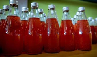 Bottles from Basil seed beverage factory conveyor belt with bottles for juice or water to distribution in business. photo