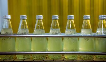 Bottles from Basil seed beverage factory conveyor belt with bottles for juice or water to distribution in business. photo