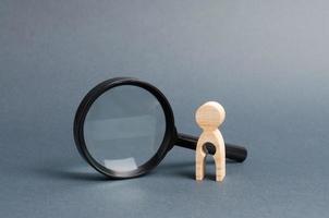 A wooden figure with a baby-shaped void stands near a magnifying glass. concept of infertility and women and the inability to have children. Abbort, the loss of a child. Treatment and Prevention photo