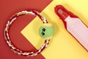 Accessories for Pets. Ring for playing with a dog, water bottle, on a red and yellow background photo