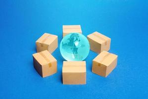 Earth globe is surrounded by boxes. Global business and transportation of goods and products. Shipping and freight, world trade and economics. Distribution, import export. commodity turnover photo