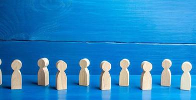 Figures of people on a blue background. Maintaining a safe distance in queue. New normal. Society concept. Communication. Population and citizens. Faceless persons. Detachment and loneliness photo