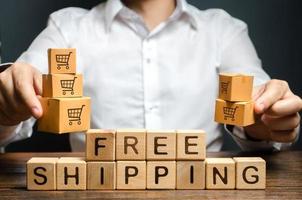 A man holds boxes over the inscription free shipping. Promotions preferential terms for large customers and product groups. Transportation of goods and services, distribution and delivery of orders. photo