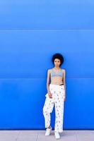 Black woman in bra near blue wall photo