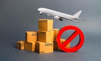 Cargo plane, many boxes and red prohibition symbol NO. Embargo trade wars. Restriction on importation, ban transit export dual-use goods to countries under sanctions. transport companies. photo