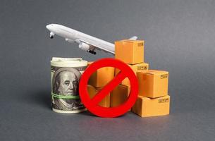 The prohibition sign NO blocks, bundle of dollars money and boxes with a airplane. Embargo, trade wars. Restriction on importation goods, proprietary for business. Sanctions and economic restrictions photo