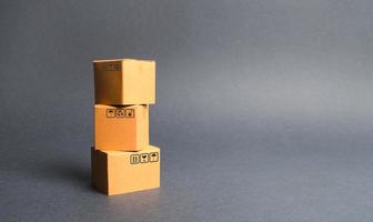 un montón de tres cajas de cartón. el concepto de productos y bienes, comercio y venta al por menor. comercio electrónico, ventas y venta de bienes a través de la plataforma de comercio en línea. importación y exportación de productos foto