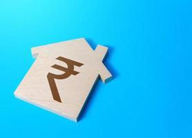 House with a indian rupee symbol. Cost estimate. Search for options, choice of residential buildings. Property price valuation evaluation. Solving housing problems, deciding buy or rent real estate. photo