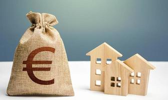 Euro money bag and residential buildings. Mortgage loan. City municipal budget. Costs of service and maintaining buildings. Property tax. Investment in real estate. Purchase of housing. photo