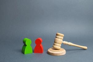 Two figures of people opponents stand near the judge's gavel. Conflict resolution in court, claimant and respondent. Court case, resolution and disputes settling disputes. The judicial system. photo