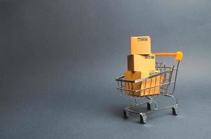 A pile of cardboard boxes in a supermarket trolley. concept of shopping in the online store . E-commerce, sales and sale of goods through online trading platforms. Consumer society. Purchasing power photo