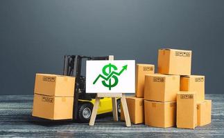 Forklift near boxes and easel with green dollar arrow up. Growth trade and production rates, increased sales. Economic growth, industry development. Marketing, price increases. High import export. photo