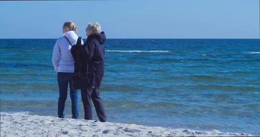 dos chicas caminan por la costa del mar negro a principios de otoño video