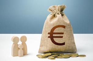 Euro money bag with money and family figurines. Financial support for social institutions. Investments in human capital, culture and social projects. Providing assistance to citizens. photo