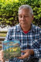 artisan who paints with his fingers on the street and creates landscapes mexico, guadalajara photo