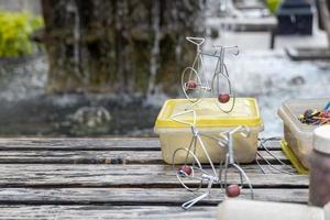 artesano en la calle haciendo figuritas de bicicletas con alambre, figuritas de metal hechas a mano mexico foto