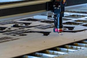 laser cutting machine, cutting wood sheets, while a man records the process, mexico photo