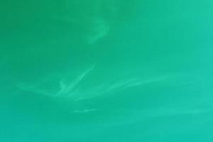 Defocus blurred transparent green colored clear calm water surface texture with splash, bubble. Shining purple water ripple background. Surface of water in swimming pool. Green bubble water shine. photo