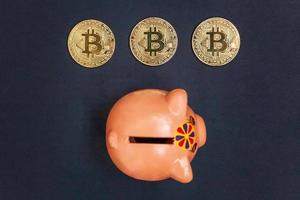 Piggy bank and golden bitcoin coin virtual money on black background. Cryptocurrency and saving concept. Electronic virtual money for web banking and international network payment photo