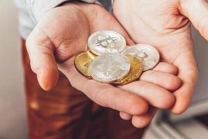 Man hand holding cryptocurrency golden and silver bitcoin coin. Electronic virtual money for web banking and international network payment. Symbol of crypto virtual currency. Mining concept. photo