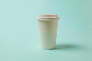 Simply design paper coffee cup on blue pastel colorful trendy background. Takeaway drink container. Good morning wake up awake concept. Template of drink mockup. Top view copy space. photo