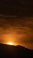 video de lapso de tiempo vertical de la espectacular puesta de sol con cielo naranja en un día soleado.