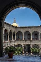 colonial architecture, arches surrounded by vegetation, play of light and shadows inside the space, natural materials photo