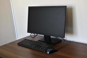 Personal computer on the desk in the office. Monitor keyboard and mouse on the table. photo