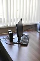 Personal computer on the desk in the office. Monitor keyboard and mouse on the table. photo