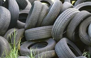 Damaged and worn old black tires on a stack. Damaged and worn old black tires on a stack. Tire tread problems. Solutions concept. Tire tread problems. photo