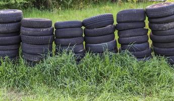 Damaged and worn old black tires on a stack. Damaged and worn old black tires on a stack. Tire tread problems. Solutions concept. Tire tread problems. photo