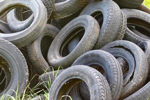 Damaged and worn old black tires on a stack. Damaged and worn old black tires on a stack. Tire tread problems. Solutions concept. Tire tread problems. photo