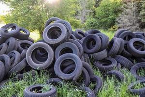 Damaged and worn old black tires on a stack. Damaged and worn old black tires on a stack. Tire tread problems. Solutions concept. Tire tread problems. photo