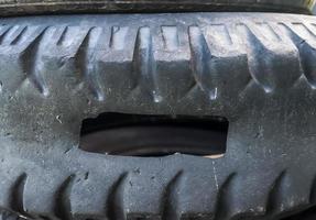 Damaged and worn old black tires on a stack. Damaged and worn old black tires on a stack. Tire tread problems. Solutions concept. Tire tread problems. photo