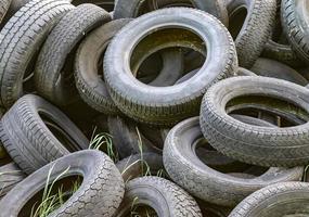 Damaged and worn old black tires on a stack. Damaged and worn old black tires on a stack. Tire tread problems. Solutions concept. Tire tread problems. photo