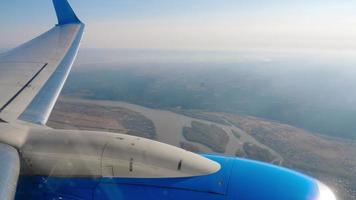 Sicht auf das Gebiet aus dem Fenster des Flugzeugs. Flugzeugmotor und Flügel aus dem Bullauge video